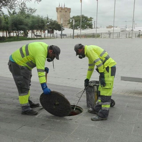 operarios abriendo tapa de alcantarillado